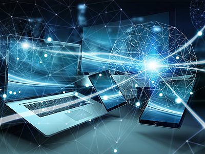 Laptop, Tablet und Smartphone sind in einem digitalen Netzwerk miteinander verbunden; strahlende Linien und geometrische Formen verstärken den futuristischen, technologischen Kontext.